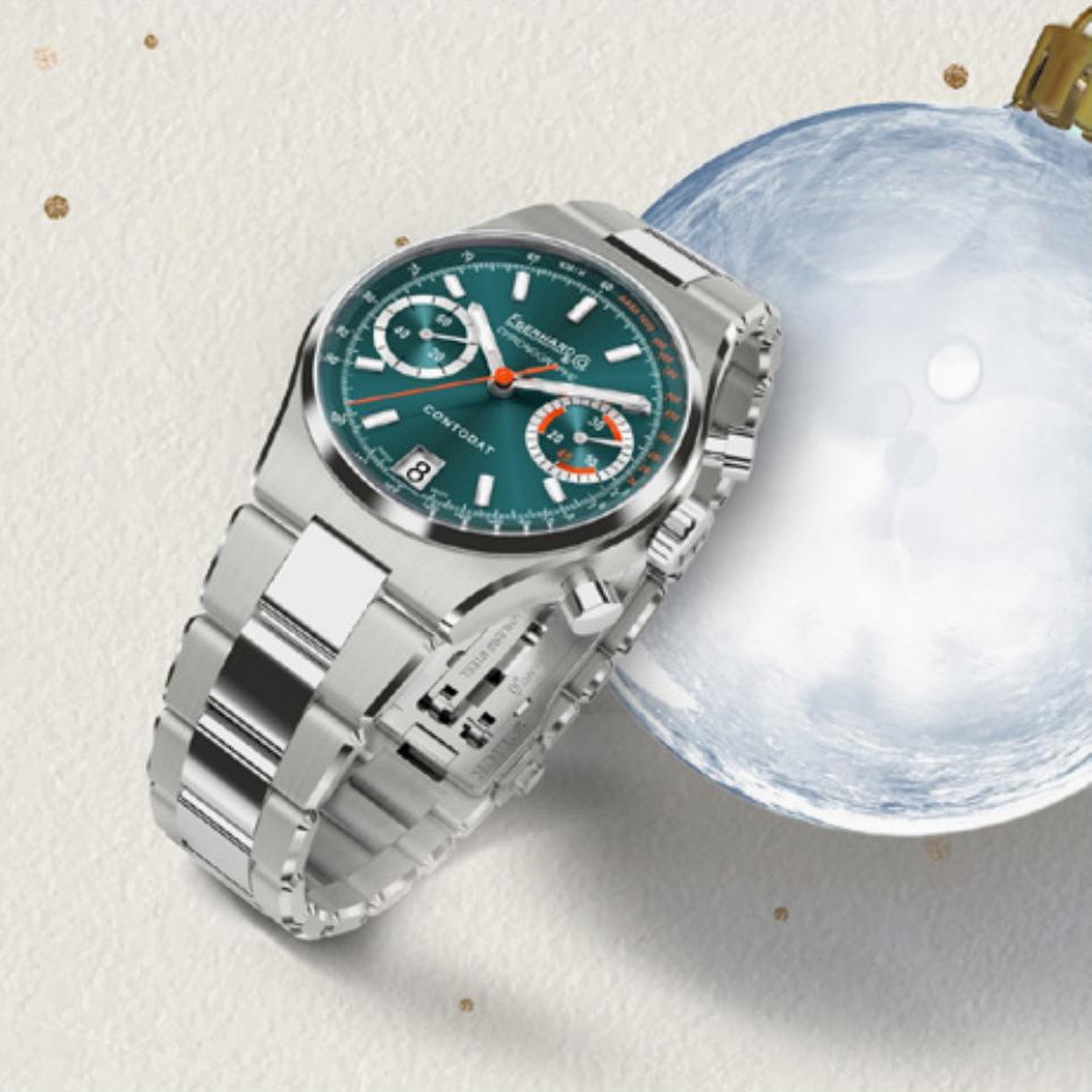 Concept Season's Greetings Eberhard & Co., cronografo quadrante verde accanto a una pallina di Natale su sfondo scuro con dettagli dorati